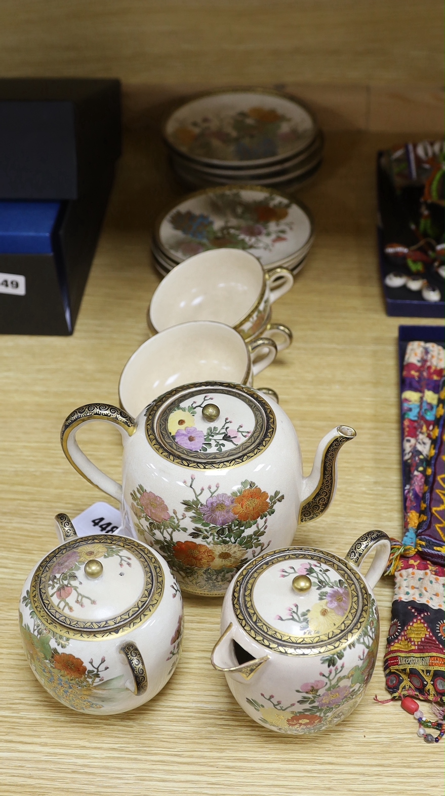 A Satsuma tea service comprising teapot, cream jug, sugar pot, four plates and four cups with saucers